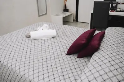 a bed with two pillows and a white box on it at 47 Steps in Rome