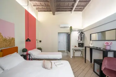 a hotel room with two beds and a desk at Pantheon Unique Rooms in Rome