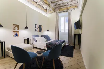 a living room with a bed and two chairs at Pantheon Unique Rooms in Rome