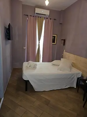 a bedroom with a large white bed with a window at Le terrazze di Alberto in Rome