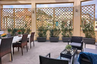 a patio with tables and chairs and potted plants at Triumph Apartment in Rome