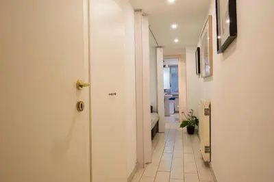 a hallway with a white door and a bathroom at Chroma Apt Farinone 28 in Rome