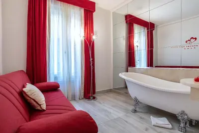 a bathroom with a white tub and a red couch at Ripetta Luxury Del Corso in Rome