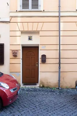 a red car parked in front of a building with a door at Rione Di Roma Center Apartment in Rome