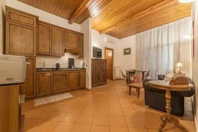 a kitchen with wooden cabinets and a table at GuestHost - Elegant Apartment in Rome in Rome