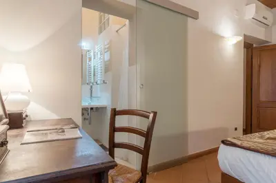 a bedroom with a desk and a bed and a table at GuestHost - Elegant Apartment in Rome in Rome