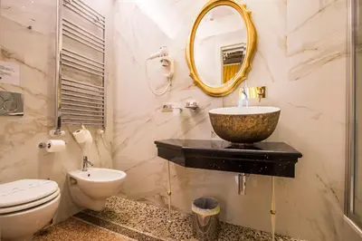 a bathroom with a sink and a toilet and a mirror at Trastevere Royal Suite Trilussa in Rome