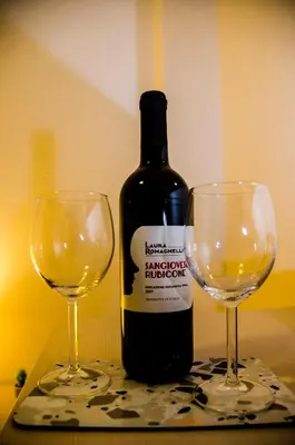 a bottle of wine and two wine glasses on a table at Hello Rose - Appartamento intero in Rome