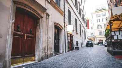 a cobblestone street in an old city with buildings at My Trevi Rooms 88 in Rome