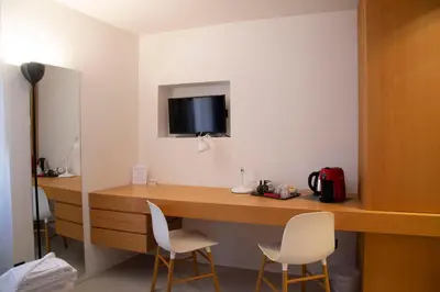 a room with a desk with two chairs and a tv at Residenza Pantaleo in Rome