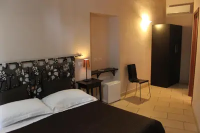 a bedroom with a bed and a desk and a chair at San Lorenzo Rooms in Rome