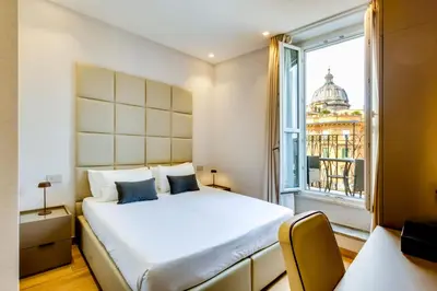 a bedroom with a bed and a large window at V Collection Relais Badoer in Rome