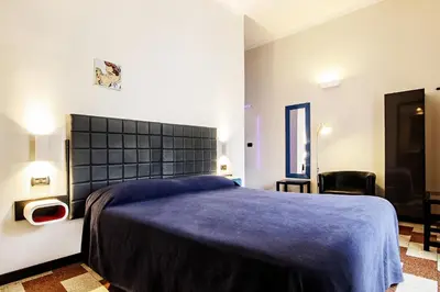 a bedroom with a large bed with a blue blanket at Old Kitchen Vatican Suites in Rome