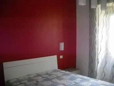 a bedroom with a red wall and a bed at Bed&bookofrome in Rome