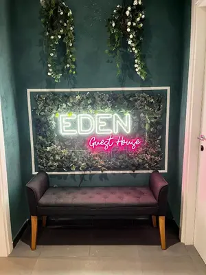 a sign on a wall with a bench in a room at Eden guest house in Rome