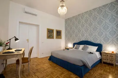 a bedroom with a blue bed and a desk and a table at Your Secret Pantheon in Rome