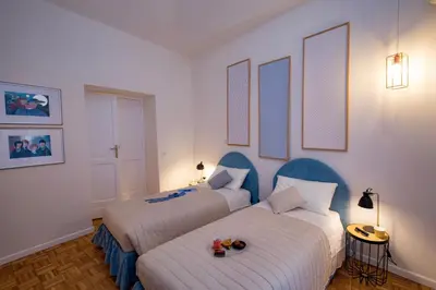 two beds in a room with white walls and blue accents at Your Secret Pantheon in Rome