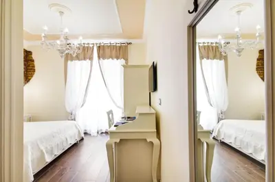 a bedroom with two beds and a mirror at Lunaria Suites Rome Vaticano in Rome