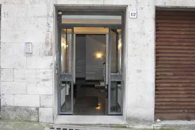 an open glass door of a building with a shutter at Lofts In Rome in Rome