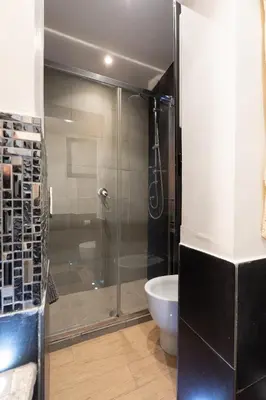 a bathroom with a glass shower and a sink at Vicolo Navona in Rome
