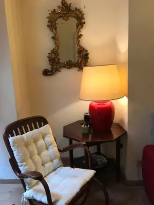 a lamp on a table next to a chair and a table with a lamp gmaxwell at Stylish apartment in central Rome 