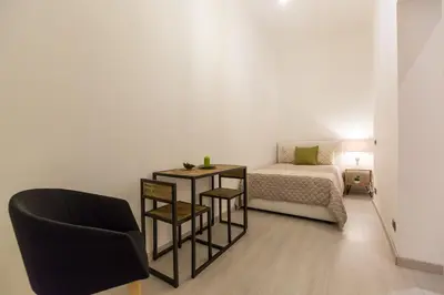 a small bedroom with a bed and a chair at Lovely New home, Trastevere! in Rome