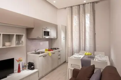 a kitchen and living room with a couch and a table at Well Done Montebello in Rome