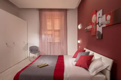 a bedroom with a large bed with red walls at Well Done Montebello in Rome