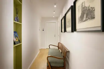 a hallway with a bench and paintings on the wall at Velantia Vaticano - Guesthouse in Rome