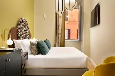 a bedroom with a bed with a window and a chandelier at Velantia Vaticano - Guesthouse in Rome