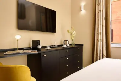 a bedroom with a black dresser with a television on the wall at Velantia Vaticano - Guesthouse in Rome