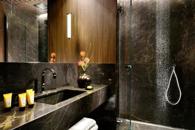a bathroom with a sink and a vase of flowers at The First Dolce - Preferred Hotels & Resorts in Rome
