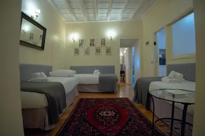 a hotel room with two beds and a table at MGPGroup Guest House Navona in Rome