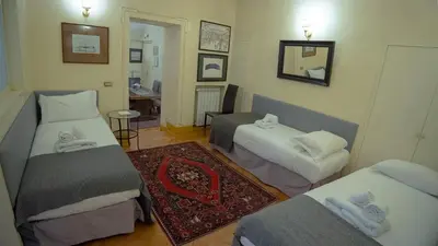 a room with three beds and a mirror at MGPGroup Guest House Navona in Rome