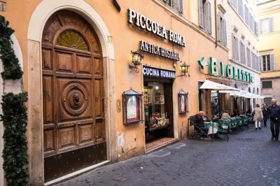 a building with a large wooden door on a street at Amazing Trevi Fountain in Rome