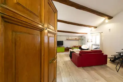 a door to a living room with a red couch at CasaJusta Trastevere in Rome