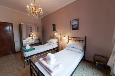 two twin beds in a room with a chandelier at Piazza Bologna in Rome