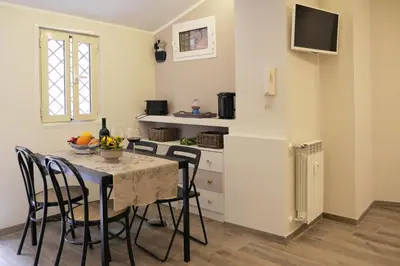 a kitchen and dining room with a table and chairs at Pisetzky-Spadaro Apartments - Vegezio Roma in Rome