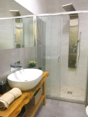 a bathroom with a sink and a glass shower at Pisetzky-Spadaro Apartments - Vegezio Roma in Rome