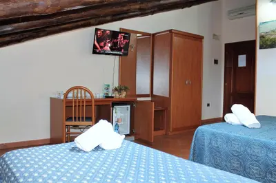 a bedroom with two beds and a tv on the wall at Nights In Rome in Rome