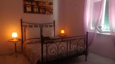 a bedroom with a bed with two lamps and a window at roma capoccia b&b in Rome