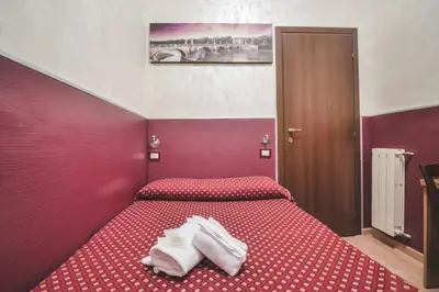 a red bedroom with two beds with white towels on them at Vertex Homes in Rome