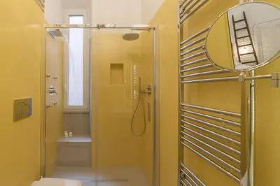 a bathroom with a shower and a toilet and a mirror at Romantic Vintage Colosseum Suite in Rome