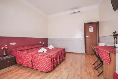 a bedroom with a red bed with two towels on it at Vertex Guest House in Rome