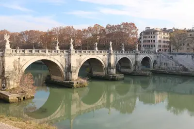 a stone bridge over a river in a city at Residenza Adriana in Rome