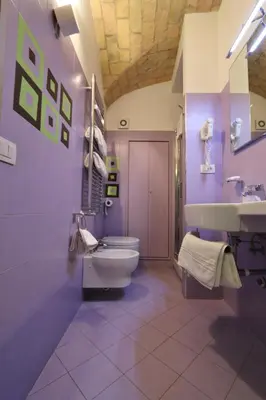 a purple bathroom with a toilet and a sink at Residenza Adriana in Rome