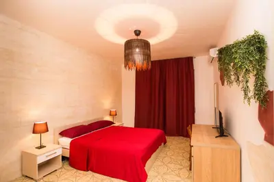a bedroom with a red bed with a red blanket at Quelli della via Gluck in Rome