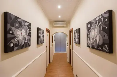 a hallway of a hospital with paintings on the walls at Filomena Arthouse in Rome