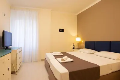 a bedroom with two beds and a flat screen tv at Relais central Turati in Rome