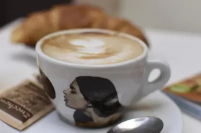 a cup of coffee with a picture of a woman at Relais central Turati in Rome